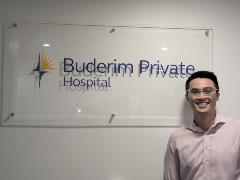 Medical student Rees Telford stands beside a Buderim Private Hospital sign. 