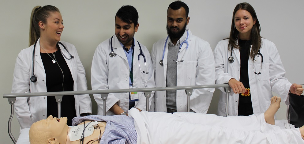clinical School student group inspecting teaching mannequin